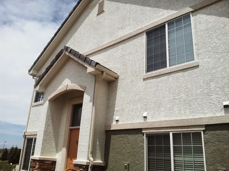 Exterior home repaint with crisp siding and trim under a bright mountain sky